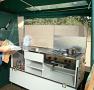 Luxury trailer tent kitchen with double burner, grill, sink and cupboard storage space